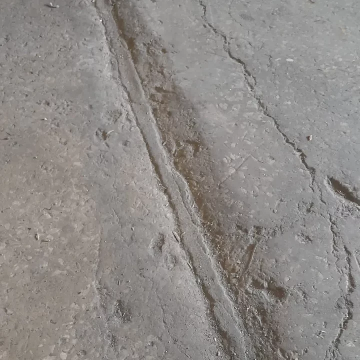 Głębokie spękania strukturalne i uszkodzenia krawędzi dylatacji w starym lastryko