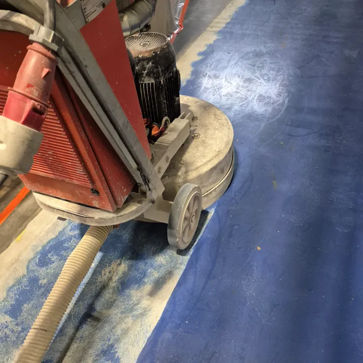 Pracownicy Probeton przygotowują betonową nawierzchnię hali do renowacji za pomocą profesjonalnych maszyn szlifierskich